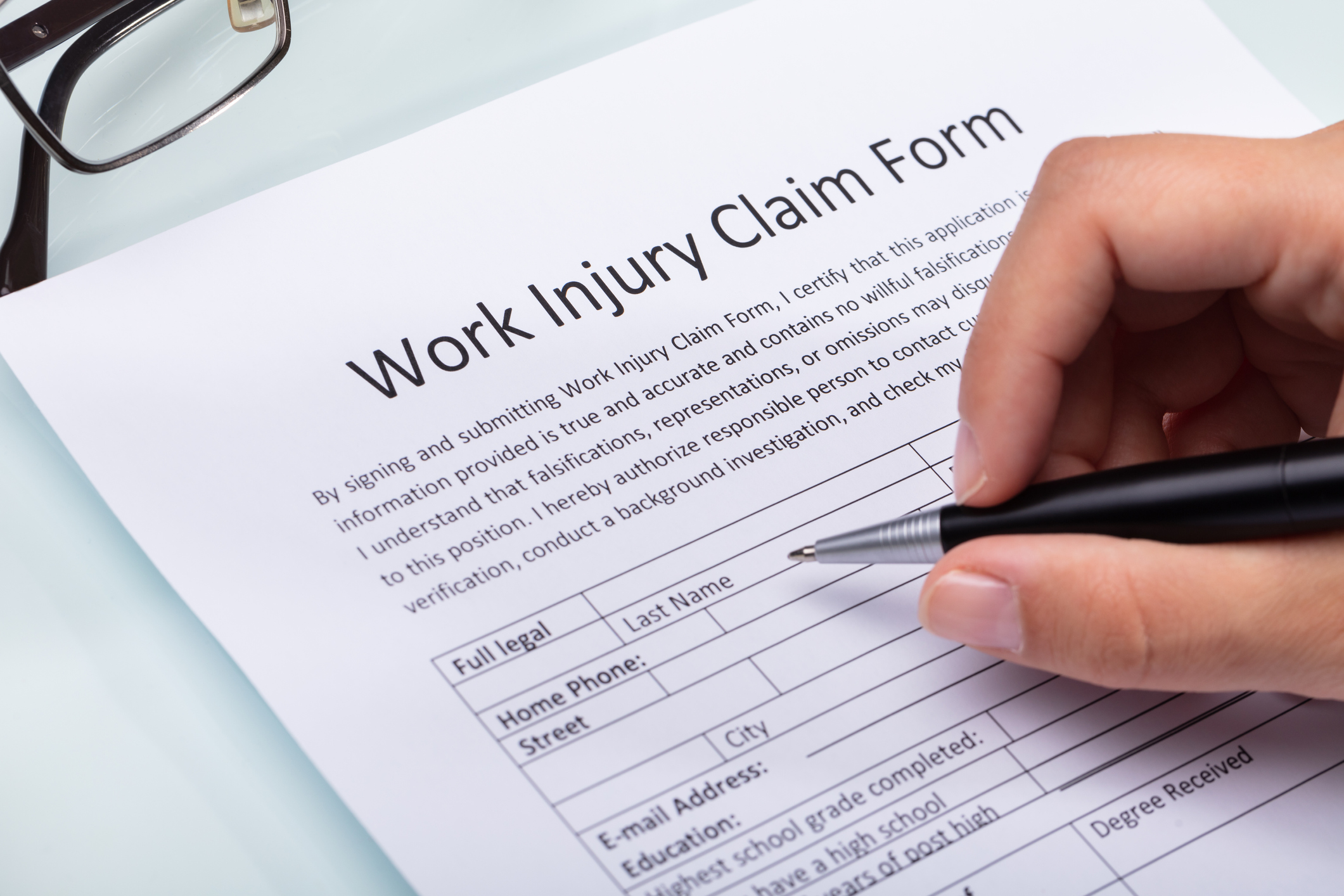 woman-filling-work-injury-claim-form-1042650458_2125x1416